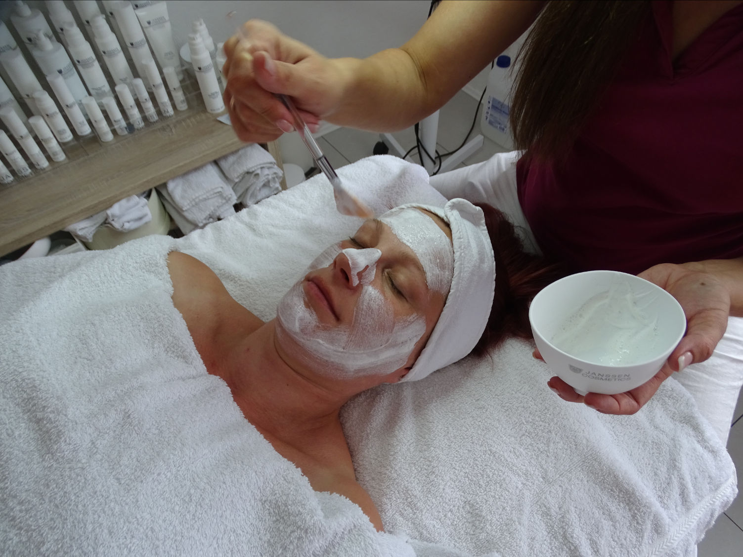 Gesichtsbehandlung Gesicht Pflege Creme Augen zu Frau wird behandelt